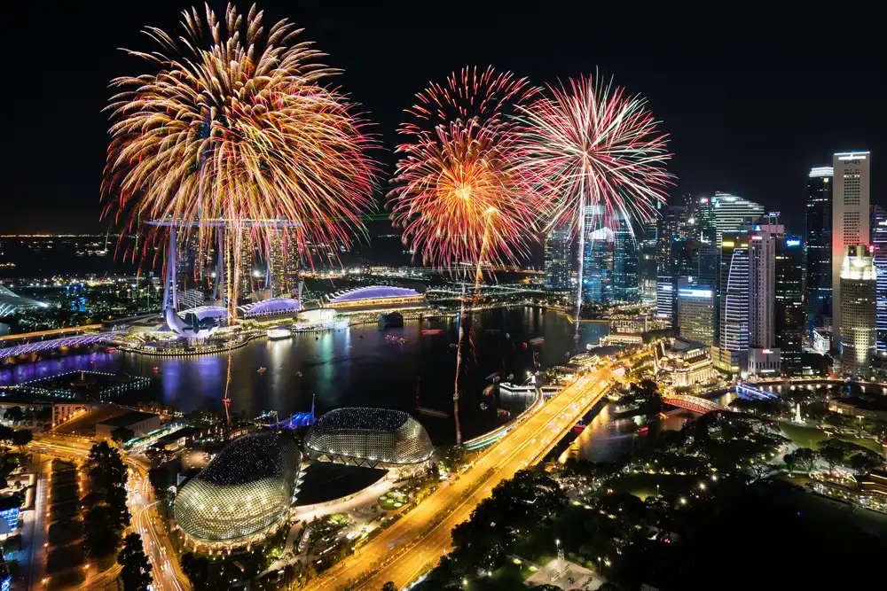 Fireworks over Marina Bay in Singapore during a festival, perfect for travellers staying at a hotel near MRT Singapore.