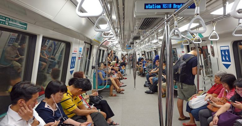 Passengers riding the MRT in Singapore, a fast and affordable way to reach events when staying at a hotel near MRT Singapore.