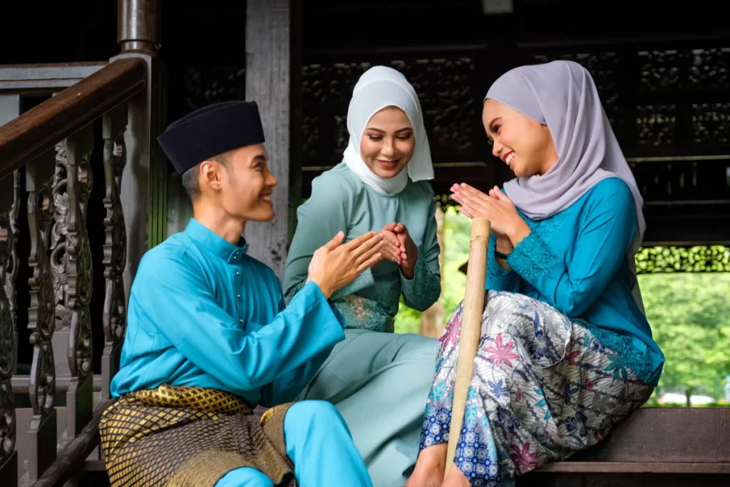 Malay muslim people showing a greeting gesture during their Hari Raya Aidilfitri celebration.