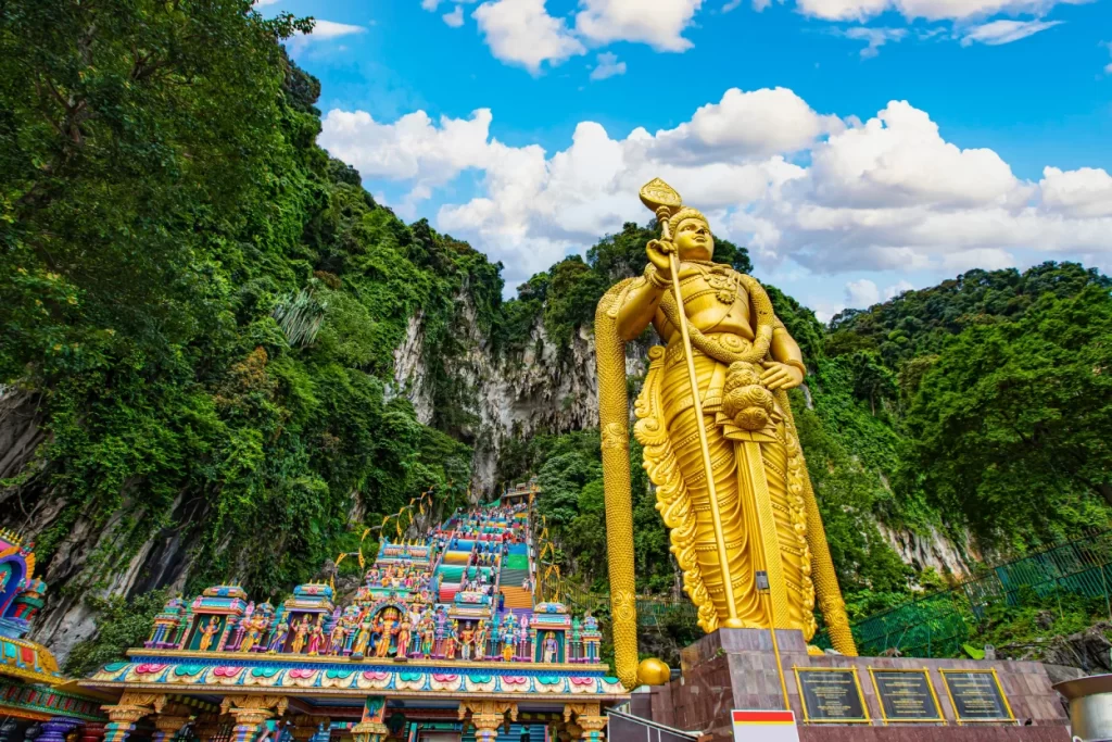 The Batu caves featuring a tall, golden Lord Murugan Statue